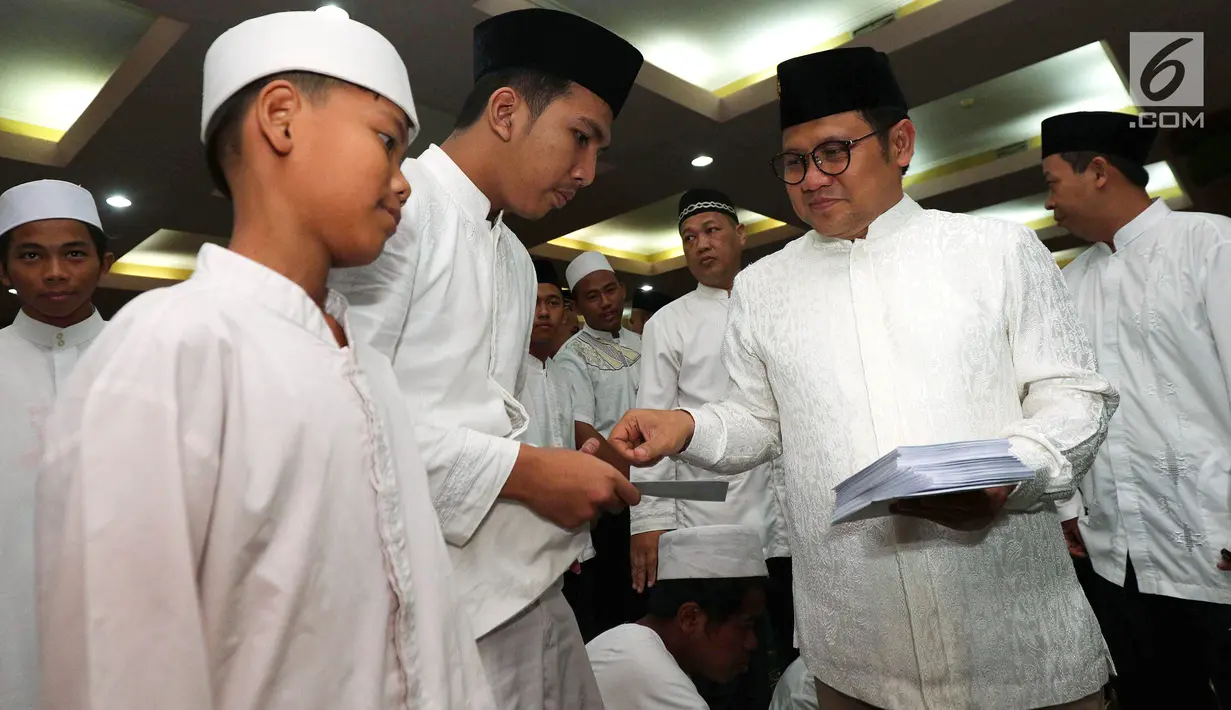 Ketua Umum PKB Muhaimin Iskandar memberikan santunan kepada anak yatim piatu acara Parlemen Mengaji di Masjid Baiturrahman, Kompleks Parlemen Senayan, Jakarta, Selasa (29/5). Kegiatan ini digelar Fraksi PKB. (Liputan6.com/Johan Tallo)