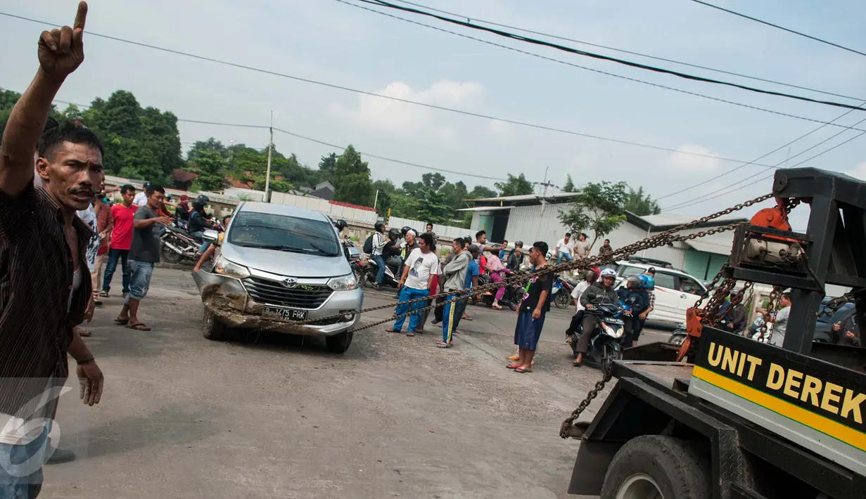 Petugas dibantu warga mengevakuasi mobil yang terperosok di Saluran Ispeksi Kalimalang, Jabar, Minggu (7/5). Tidak ada korban meninggal dalam kejadian tersebut. (Liputan6.com/Gempur M Surya)