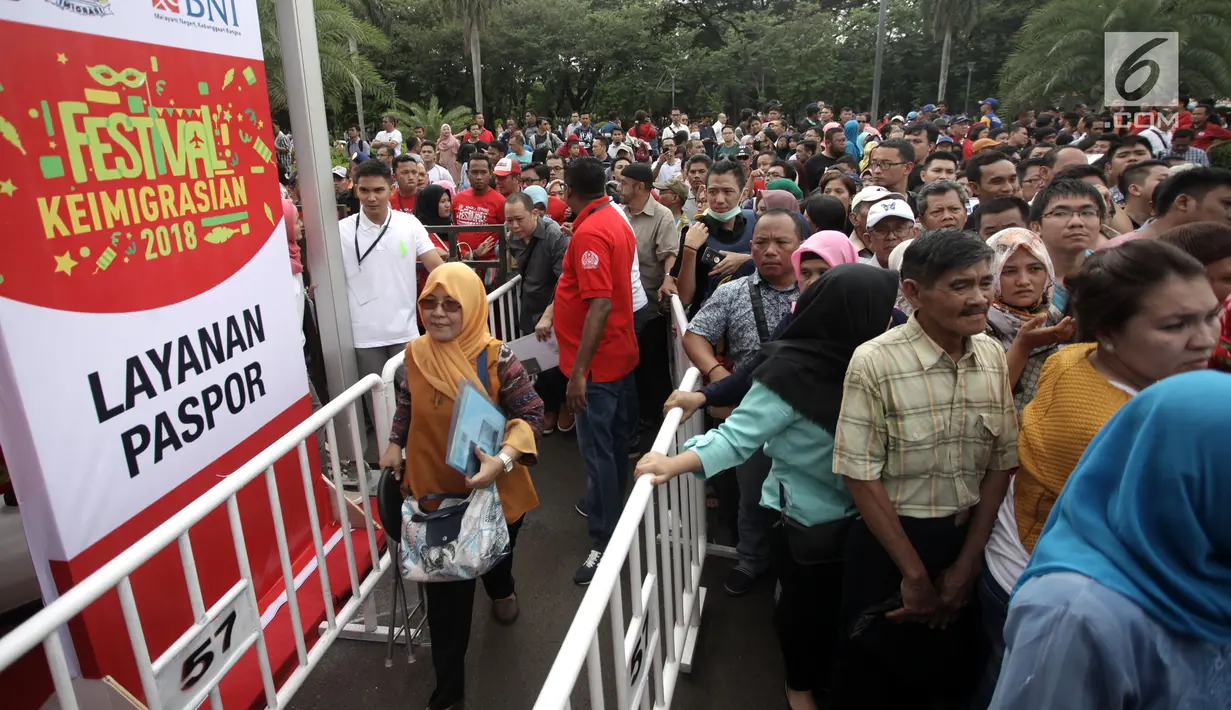 Petugas mengatur warga yang mengantre untuk membuat paspor dalam acara Festival Keimigrasian 2018 di Lapangan Barat Daya Monas, Jakarta, Minggu (21/1). Para pembuat paspor mengantre sejak pagi. (Liputan6.com/Arya Manggala)