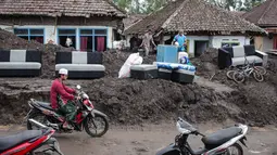 Bahkan, sebagian di antaranya rata dengan fondasi tanah disapu material vulkanik. Tampak dalam foto, warga menyelamatkan barang-barang dari sebuah rumah yang hancur akibat aliran piroklastik Gunung Semeru di Desa Supiturang, Lumajang, Jawa Timur, pada Jumat 21 November 2025. (Agus Harianto/AFP)