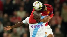 Pemain Manchester United Raphael Varane (kanan) berebut bola dengan pemain Crystal Palace Jean-Philippe Mateta pada pertandingan sepak bola putaran ketiga Piala Liga Inggris atau Carabao Cup 2023/2024 di Stadion Old Trafford, Manchester, Inggris, Selasa (26/9/2023). Manchester United menang 3-0 atas Crystal Palace. (AP Photo/Dave Thompson)