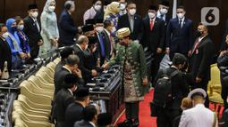 Presiden Joko Widodo (baju hijau) menyapa anggota dewan saat memasuki ruang sidang saat menghadiri Sidang Tahunan MPR dan Sidang Bersama DPR - DPD Tahun 2022 di Gedung Nusantara, Kompleks Parlemen, Senayan, Jakarta, Selasa (16/8/2022). Jokowi menyampaikan pidato kenegaraan dalam sidang tahunan MPR RI dan sidang bersama DPR RI dan DPD RI Tahun 2022. (Liputan6.com/Johan Tallo)