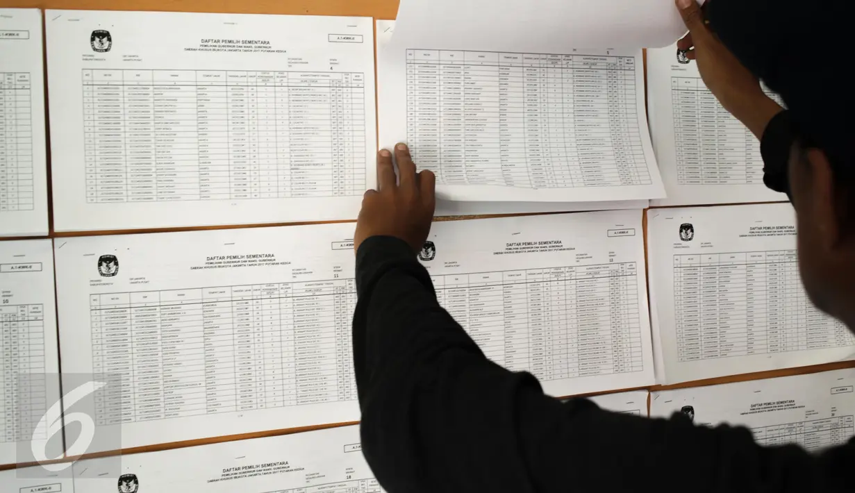 Warga melihat daftar pemilih sementara untuk memastikan keikutsertaannya dalam Pemilihan Gubernur DKI Jakarta putaran kedua di Kantor Kelurahan Kramat, Senen, Jakarta, Rabu (5/4). (Liputan6.com/Faizal Fanani)