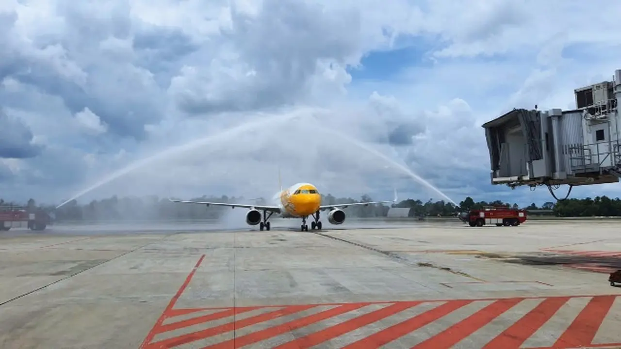 Water salute dari petugas pemadam Bandara SSK II Pekanbaru terhadap maskapai dari Singapura yang baru mendarat.