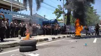 Massa yang berdemonstrasi memprotes insiden Bendera Indonesia terbalik sempat membakar ban di depan Konjen Malaysia di Medan. (Liputan6.com/Reza Efendi)