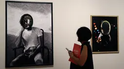 Seorang wanita mengamati karya seni Todd Gray pada pameran 'Michael Jackson: On The Wall' di National Potrait Gallery, London, Rabu (27/6). Dalam pameran ini, karya-karya yang dihasilkan lebih dari 40 seniman dipamerkan. (AP/Kirsty Wigglesworth)