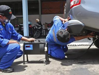Petugas melakukan uji emisi buang kepada kendaraan di Kantor Dinas Lingkungan Hidup DKI Jakarta kawasan Kramat Jati, Jakarta, Selasa (3/11/2020). Uji emisi yang diberlakukan secara gratis itu akan rutin digelar setiap Selasa dan Kamis. (Liputan6.com/Herman Zakharia)