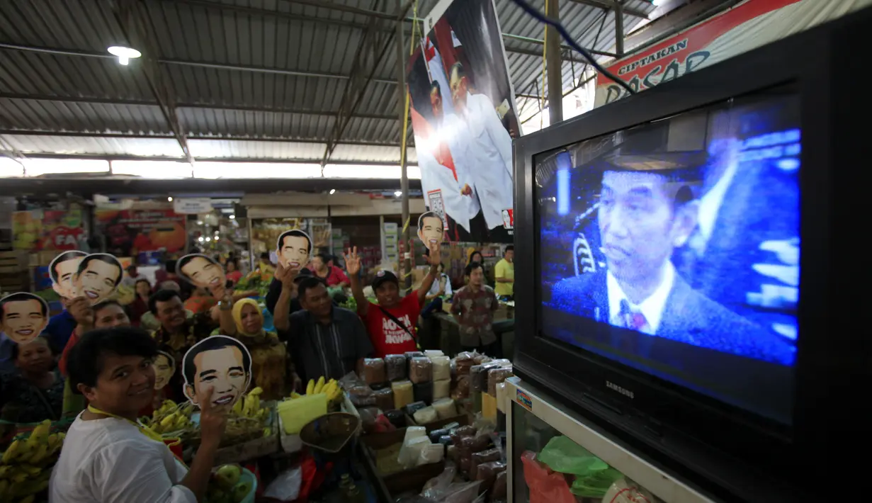 Para warga menonton bersama melalui TV acara pelantikan Presiden, Joko Widodo dan wakilnya, Jusuf Kalla di Pasar Gede, Solo, (20/10/14). (ANTARA FOTO/Maulana Surya)