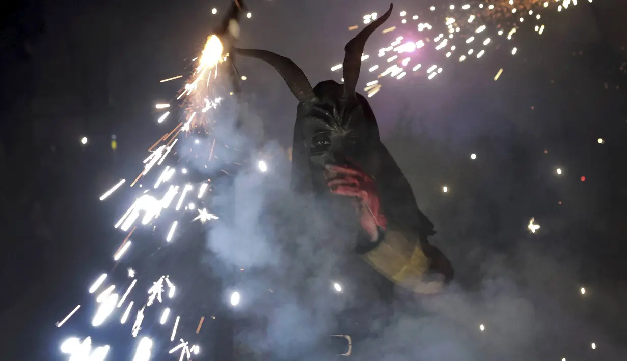 Seorang warga berpakaian seperti hantu dengan memegang tongkat kembang api selama perayaan " Correfocs ", Mallorca, Spanyol, (24/1). Ini merupakan perayaan tradisional yang menandai menandai akhir dari perayaan lokal di Palma. (REUTERS / Enrique Calvo)
