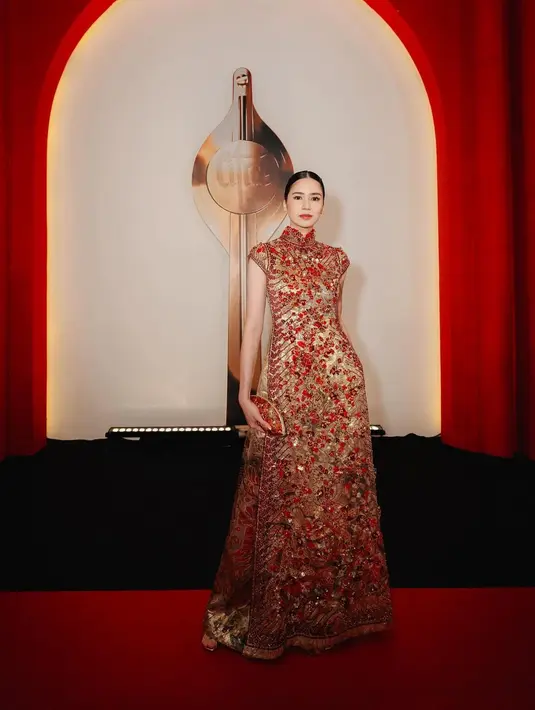 Menggunakan busana cheongsam berwarna emas dengan detail bordiran dan beads warna merah, Laura Basuki nampak sangan anggun dan elegan. [@laurabas]