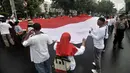 Massa yang tergabung dalam Gerakan Jaga Indonesia (GJI) membentangkan bendera Merah Putih raksasa saat menggelar aksi di depan Balai Kota, Jakarta, Kamis (29/11). (Merdeka.com/Iqbal S. Nugroho)