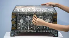 Karyawan rumah lelang Sotheby melihat peti mati bertatahkan mutiara yang diperkirakan bernilai 250.000-350.000 pound sterling sebagai bagian dari penjualan Arts of the Islamic World dan India pada 31 Maret di London, Inggris, Senin (29/3/2021). (Dominic Lipinski/PA via AP)
