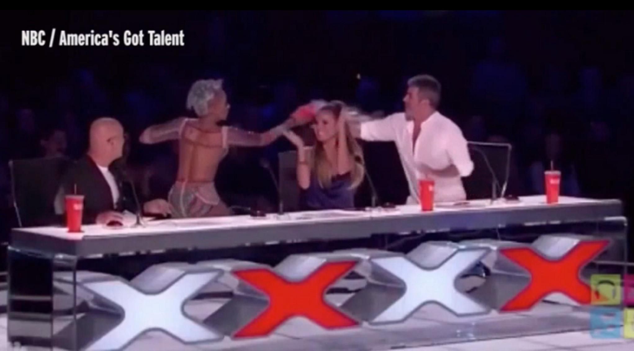 	Mel B saat menyiram Simon Cowell dengan air dari gelas minumnya (YouTube)