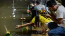 Orang-orang menghanyutkan 'krathong' untuk menandai festival Loy Krathong di sebuah danau di Narathiwat, Thailand,  Senin (11/11/2019). Loi bermakna melarung/mengapung, sedangkan Krathong bermakna wadah yang terbuat dari daun yang bisa mengapung di atas air. (Madaree TOHLALA / AFP)