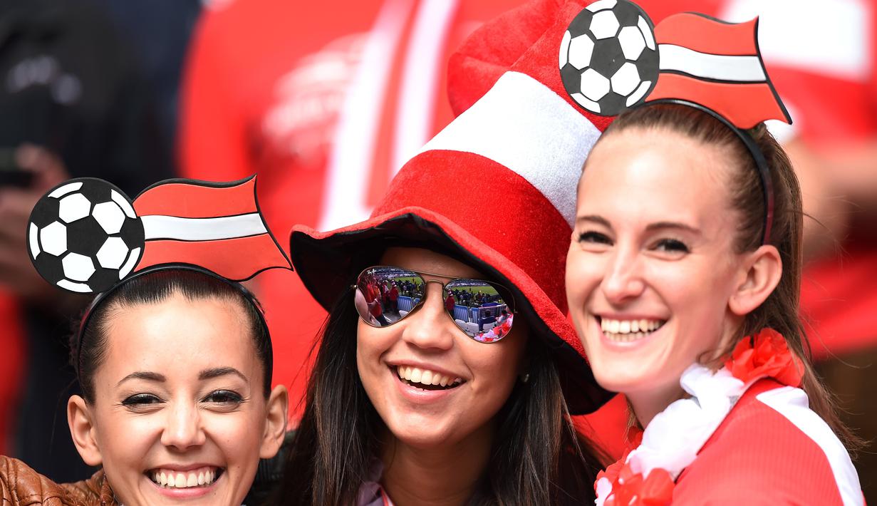 Suporter cantik Austria ini tampil dengan hiasan kepala berbentuk bola saat mendukung timnya melawan Hungaria di Stadion Matmut Atlantique, Bordeaux, (14/6/2016). (AFP/Nicolas Tucat)