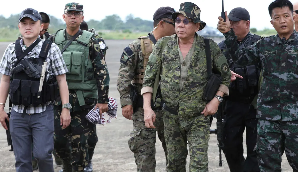 Presiden Filipina, Rodrigo Duterte bersiap naik helikopter untuk melakukan kunjungan ke medan pertempuran di Marawi, Kamis (20/7). Kunjungan dilakukan ketika pasukan masih terlibat pertarungan dengan kelompok Maute yang berafiliasi dengan ISIS. (AP Photo)