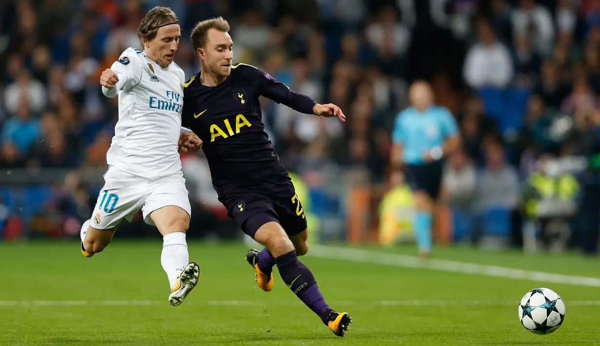 Pemain Real Madrid, Luka Modric berusaha merebut bola dari pemain Tottenham Hotspur, Christian Eriksen pada laga lanjutan fase Grup H Liga Champions di Santiago Bernabeu, Selasa (17/10). Madrid berbagi angka dengan Tottenham 1-1.  (AP/Francisco Seco)