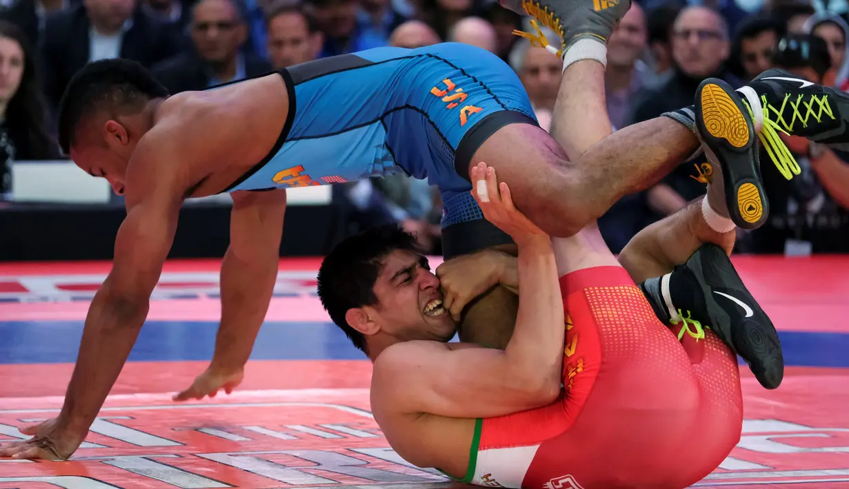 Pegulat dari AS, Mark Hall (biru) melawan Ahmad Bazrighaleh dari Iran pada Beat the Streets, Times Square, New York (19/5).Gelaran pertandingan gulat yang dibuat oleh Mike Novogratz ini merupakan salah satu pengumpulan dana. (REUTERS/Adrees Latif)