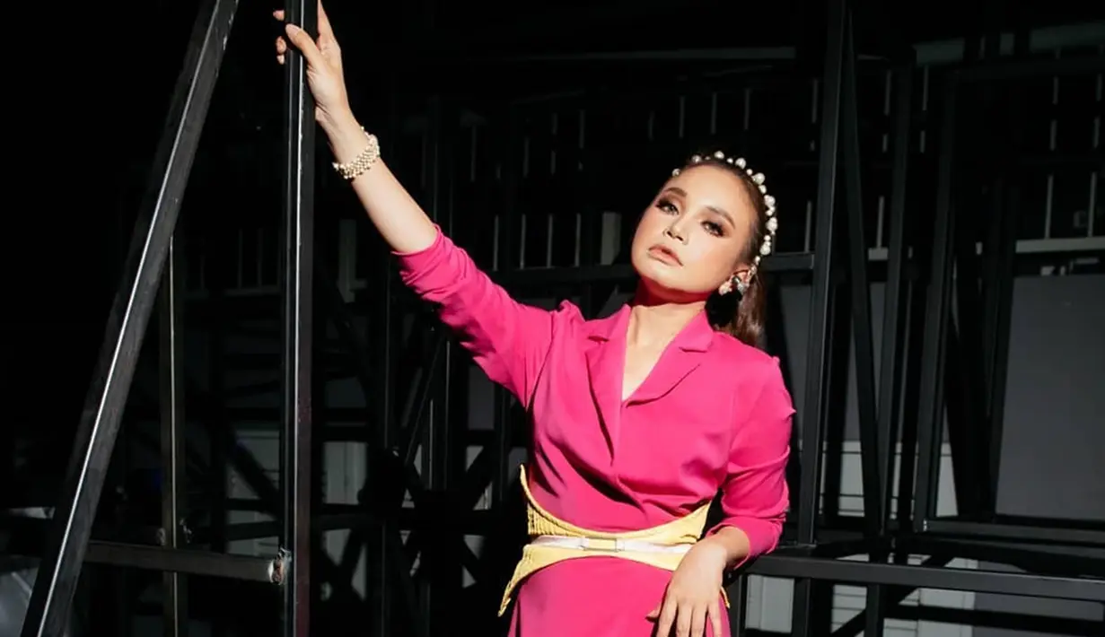 Tak hanya dalam kesehariannya, ketika manggung pun Rossa sering terlihat mengenakan bando dengan model yang unik dan elegan. Pakai jumpsuit warna merah muda, Rossa semakin pancarkan pesonanya ketika diatas panggung. Rambut yang dikuncir dengan bando mutiara mendukung penampilannya jadi lebih menawan. Selain outfit dan gaya rambut, makeup tentunya disesuikan dengan tema penampilan Rossa. (Liputan6.com/IG/@itsrossa910)