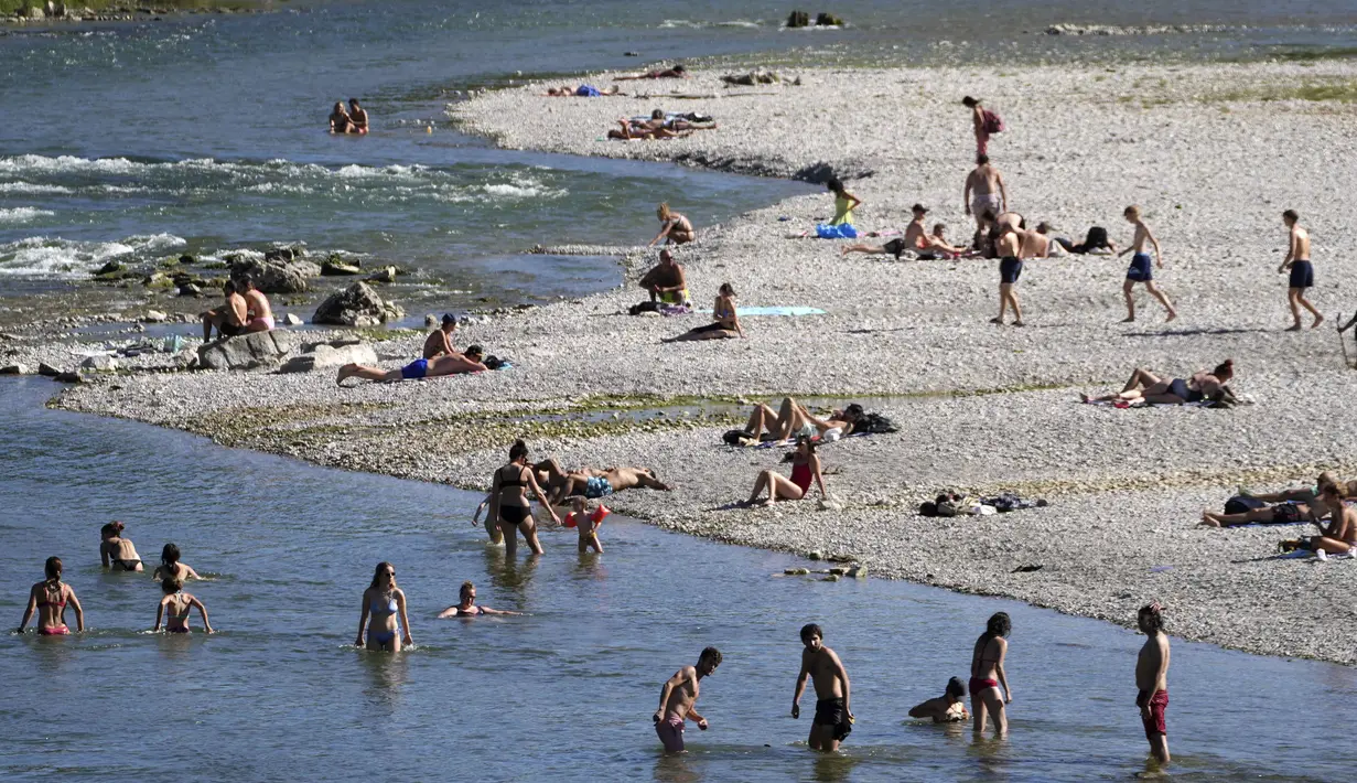 Orang-orang menikmati cuaca musim panas di tepi Sungai Isar, Munich, Jerman, 3 Agustus 2022. (AP Photo/Matthias Schrader)