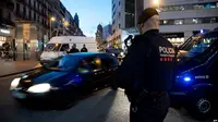 Polisi wilayah Catalonia Mossos d’Esquadra dan polisi Garda Kota mengawasi pintu masuk jalan Ramblas di Barcelona, 24 Desember 2018 (AFP)