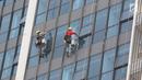 Pekerja membersihkan kaca gedung bertingkat di Jakarta, Kamis (18/10). Kepala Divisi Komunikasi BPJS Ketenagakerjaan Irvansyah Utoh Banja mengatakan, BPJS Ketenagakerjaan menargetkan kepesertaan BPJS Ketenagakerjaan 2018. (Liputan6.com/Immanuel Antonius)