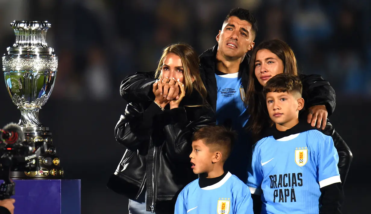 Pemain Uruguay, Luis Suarez (tengah) bersama istri (kiri) dan ketiga anaknya tak mampu membendung air mata saat acara perpisahannya dengan Timnas Uruguay sebelum laga kualifikasi Piala Dunia 2026 melawan Paraguay yang berlangsung di Stadion Centenario, Montevideo, Uruguay, Sabtu (07/09/2024) WIB. (AFP/Dante Fernandez)