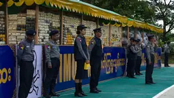 Sejumlah perwira polisi berjaga dekat narkotika sitaan sebelum acara pemusnahan pada Hari Antinarkoba Sedunia, di Yangon, Senin (26/6). Myanmar membakar opium, heroin, dan kokain senilai sekitar US$385 juta, setara Rp5,1 miliar. (AP Photo/Thein Zaw)