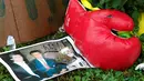 Sebuah foto dan sarung tinju diletakkan di rumah masa kecil Muhammad Ali untuk memberi penghormatan terakhir bagi petinju legendaris tersebut, di Louisville, Kentucky, AS, Sabtu (4/6). Muhammad Ali meninggal pada usai 74 tahun. (REUTERS/John Sommers II)