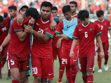 Bek Timnas indonesia U-19, Nurhidayat Haji Haris, ditenangkan Asnawi Mangkualam usai kalah dari Thailand U-19 pada laga Piala AFF U-18 di Stadion Thuwunna, Yangon, Jumat (15/9/2017). Indonesia kalah adu penalti dari Thailand. (Bola.com/Yoppy Renato)