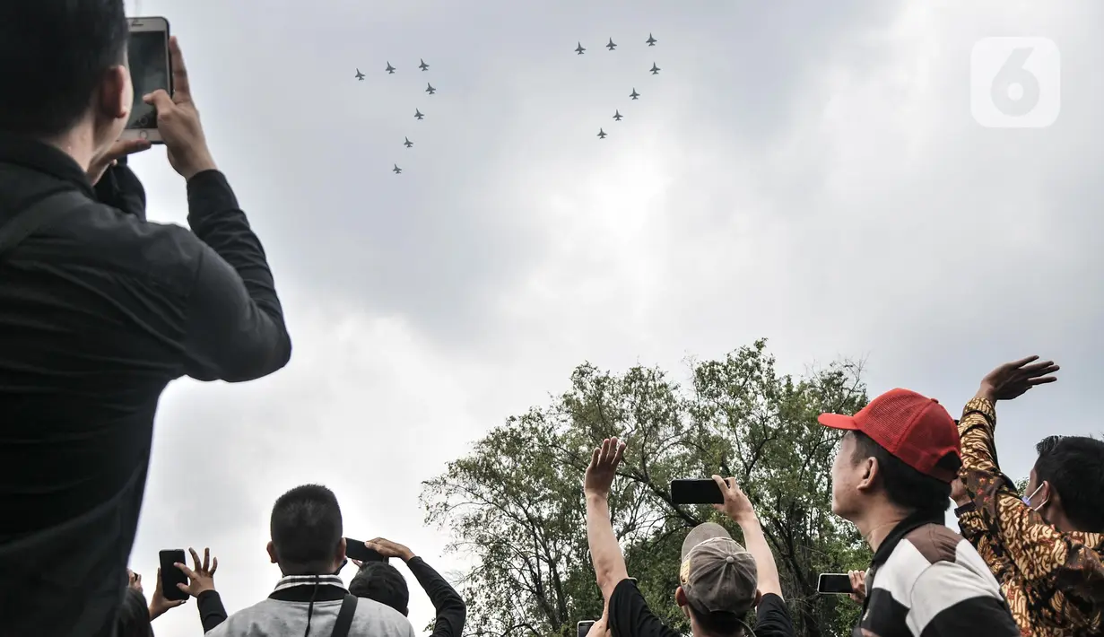 Warga menyaksikan manuver pesawat tempur TNI AU saat perayaan HUT ke-77 Republik Indonesia (RI) di Taman Aspirasi Monumen Nasional (Monas), Jakarta Pusat, Rabu (17/8/2022). Aksi akrobatik pesawat tempur dan helikopter yang membawa bendera Merah Putih tersebut disambut antusias oleh warga yang datang untuk mengikuti upacara Kemerdekaan RI. (merdeka.com/Iqbal S Nugroho)