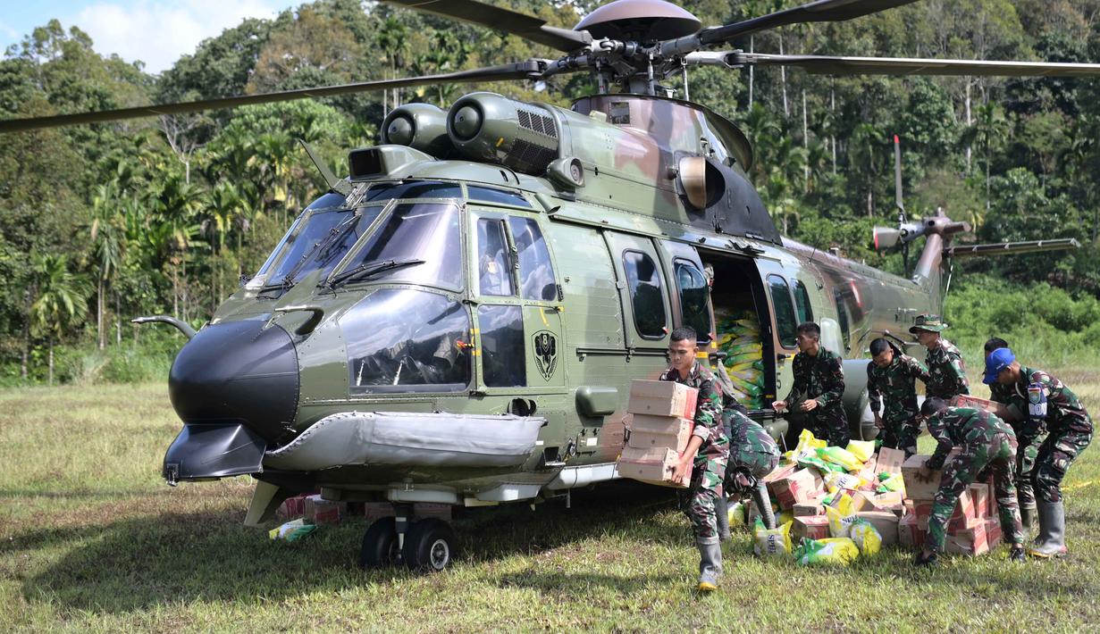 Badan Nasional Penanggulangan Bencana (BNPB), Kementerian Sosial (Kemensos), Pemerintah Provinsi Aceh, dan Pemerintah Kabupaten Aceh Tengah bersama TNI AU terus berkoordinasi dalam pengiriman bantuan. Tampak dalam foto, personel militer menurunkan barang bantuan dari helikopter TNI AU saat pendistribusian bantuan ke daerah terdampak banjir di Aceh Tengah, Sabtu 6 Desember 2025. (AP Photo/Reza Saifullah)
