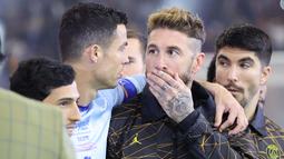 Pemain PSG, Sergio Ramos (tengah) berbincang dengan Cristiano Ronaldo saat laga Riyadh Season Cup antara Riyadh All-Star melawan PSG yang berlangsung di King Fahd Stadium, Riyadh, Jumat (20/1/2023) dini hari WIB. (AFP/Giuseppe Cacace)