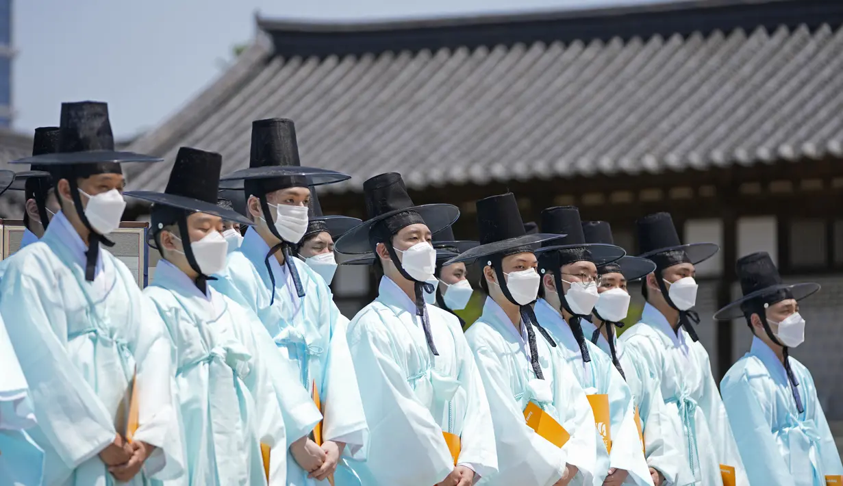 Pria mengenakan pakaian tradisional Korea Selatan menghadiri upacara untuk menghidupkan kembali Hari Kedewasaan ke-50 di Desa Namsangol Hanok di Seoul, Korea Selatan (16/5/2022). Upacara diadakan untuk pria dan wanita muda yang akan berusia 20 tahun. (AP Photo/Lee Jin-man)
