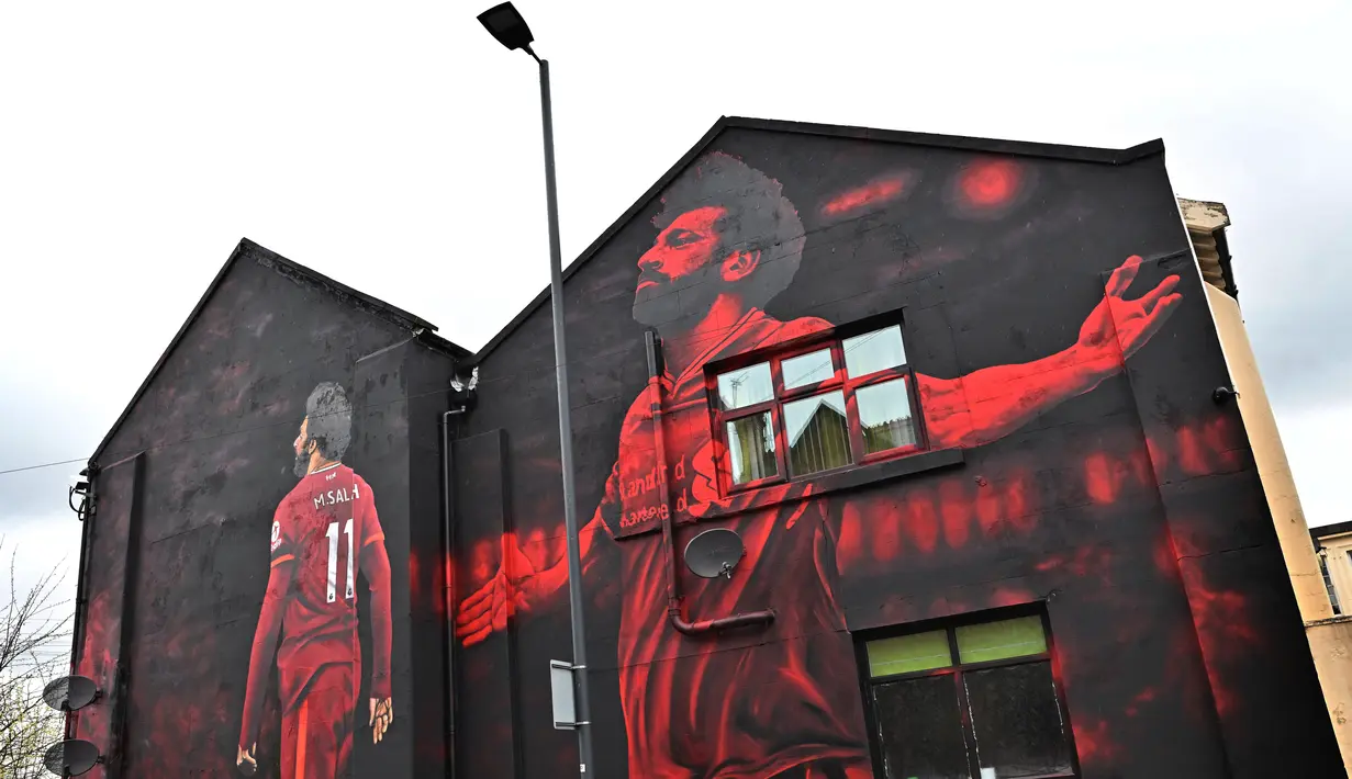 Mural seniman Inggris, John Culshaw yang menggambarkan pesepak bola Mesir Mohamed Salah dilukis di fasad bangunan dekat Stadion Anfield, di Liverpool, Rabu (30/3/2022). Mohamed Salah sudah berada di urutan kesembilan dalam daftar pencetak gol sepanjang masa Liverpool. (Paul ELLIS / AFP)