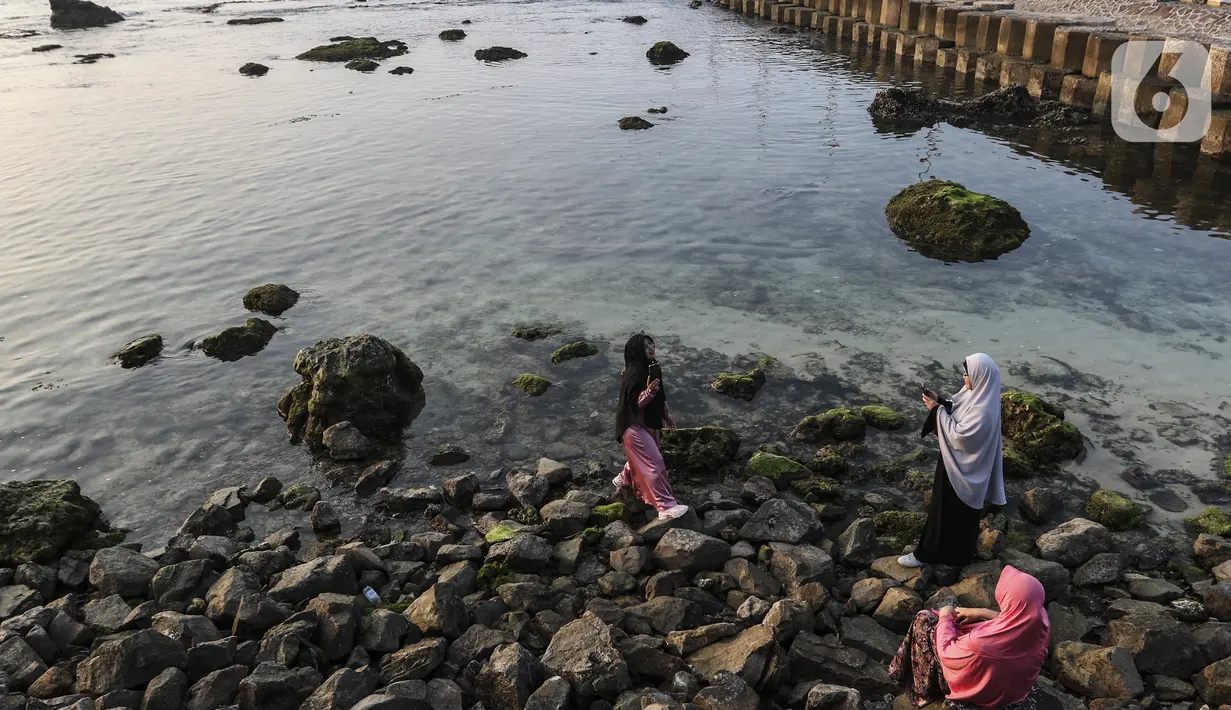 Wisatawan berfoto di kawasan Pantai Anyer, Banten, Sabtu (5/9/2020). Pantai Anyer sempat mampu menarik pengunjung setelah renovasi, namun kembali sepi akibat adanya pandemi COVID-19. (Liputan6.com/Johan Tallo)