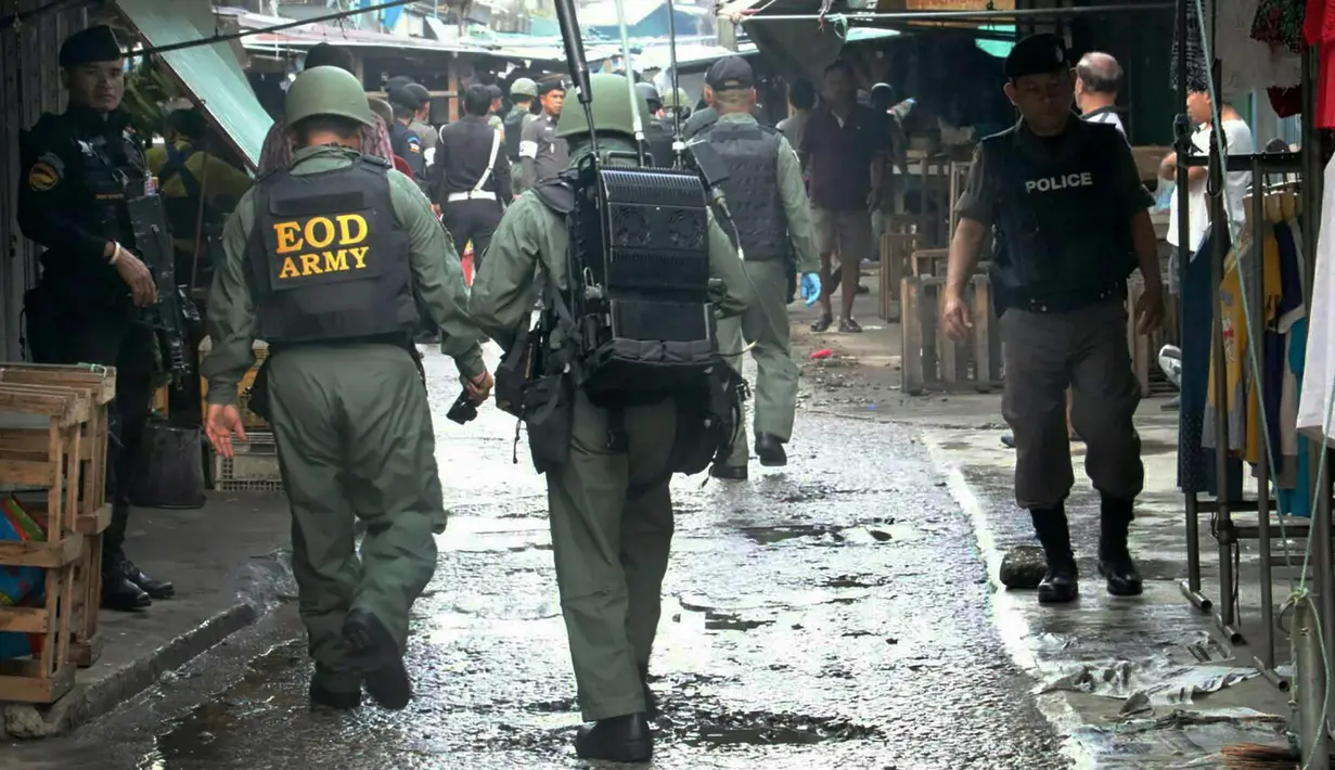 Petugas mengenakan kostum anti-bom mengecek sebuah pasar setelah terjadi bom motor di Provinsi Yala, Thailand (22/1). Sampai saat ini belum ada kelompok maupun pihak tertentu yang bertanggung jawab atas ledakan ini. (AFP Photo/Tuwaedaniya Meringing)