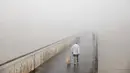 Orang-orang menyeberangi jembatan saat hari berkabut di Tel Aviv, Israel, Rabu (6/1/2021). Kabut yang cukup tebal tersebut disebabkan oleh udara yang mengalir ke darat dari laut, menyebabkan kelembaban meningkat di dataran pantai dan daerah lainnya. (AP Photo/Oded Balilty)