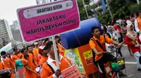 Seorang petugas Dinas Kebersihan Jakarta membawa spanduk bertuliskan 'Jakartaku Harus Bersih Dong' dalam aksi damai di Bundaran HI, Minggu (28/12/2014). (Liputan6.com/Faizal Fanani)