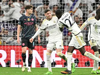 Gelandang Real Madrid, Federico Valverde (kedua kiri) merayakan golnya bersama  Antonio Rudiger saat pertandingan sepak bola leg pertama perempat final Liga Champions melawan Manchester City di Stadion Santiago Bernabeu, Madrid pada 9 April 2024. (JAVIER SORIANO/AFP)