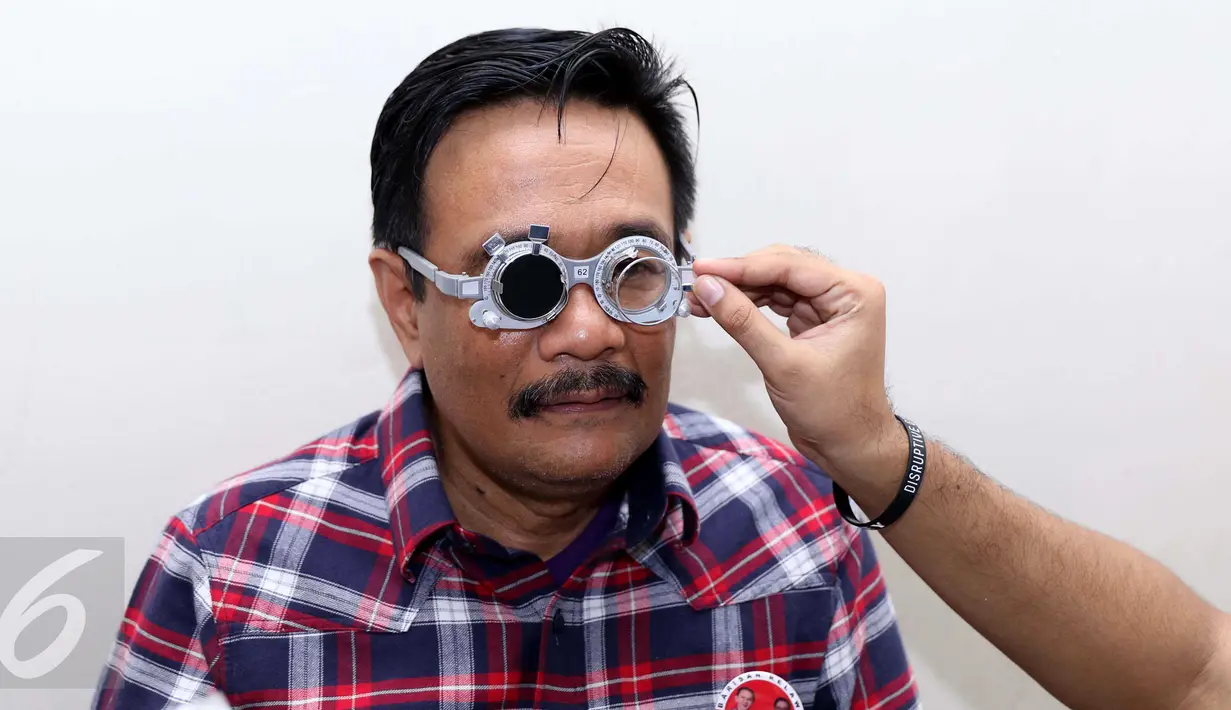 Bakal cawagub DKI Djarot Saiful Hidayat memeriksa kondisi matanya pada kegiatan bakti sosial di Cawang, Jakarta, Minggu (23/10). Dalam acara itu dibagikan 1000 kacamata gratis untuk warga Jakarta usia 39 tahun ke atas. (Liputan6.com/Gempur M Surya)