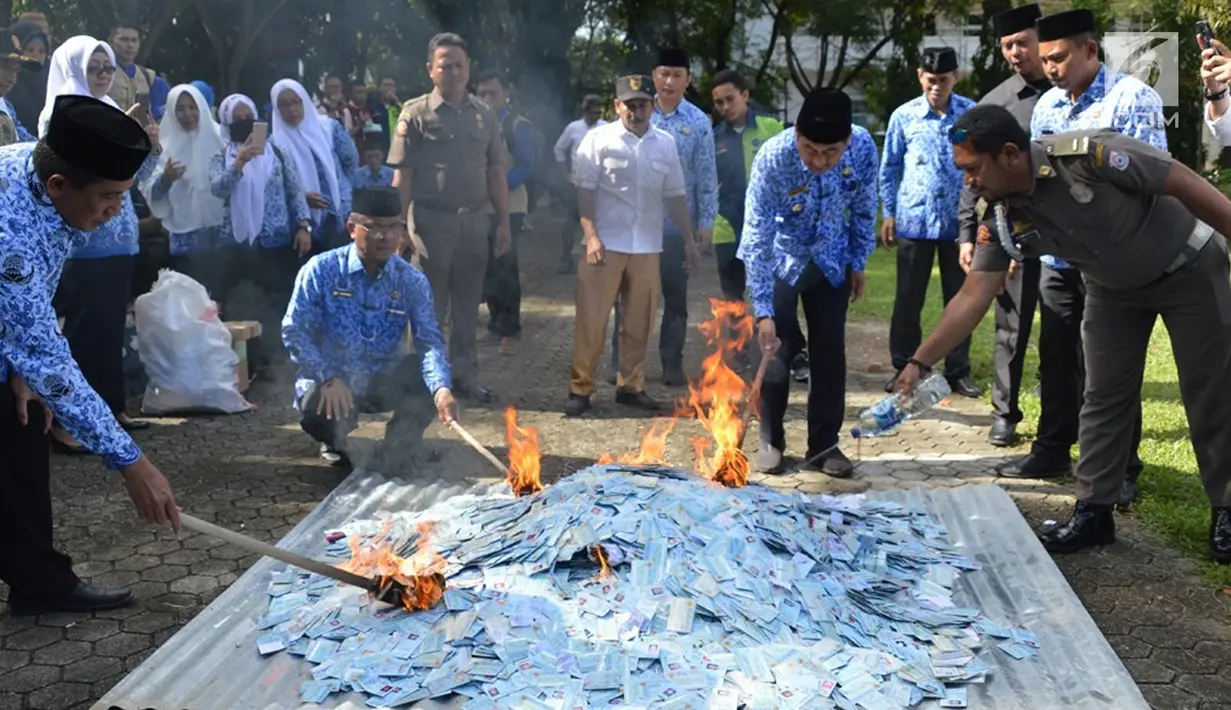 Petugas membakar KTP Elektronik yang rusak untuk dimusnahkan di halaman Kantor Bupati Bone Bolango (Bonebol), Gorontalo, Selasa (18/12). Sebanyak 28.130 E-KTP rusak dimusnahkan untuk menghindari adanya penyalahgunaan. (Liputan6.com/Arfandi Ibrahim)
