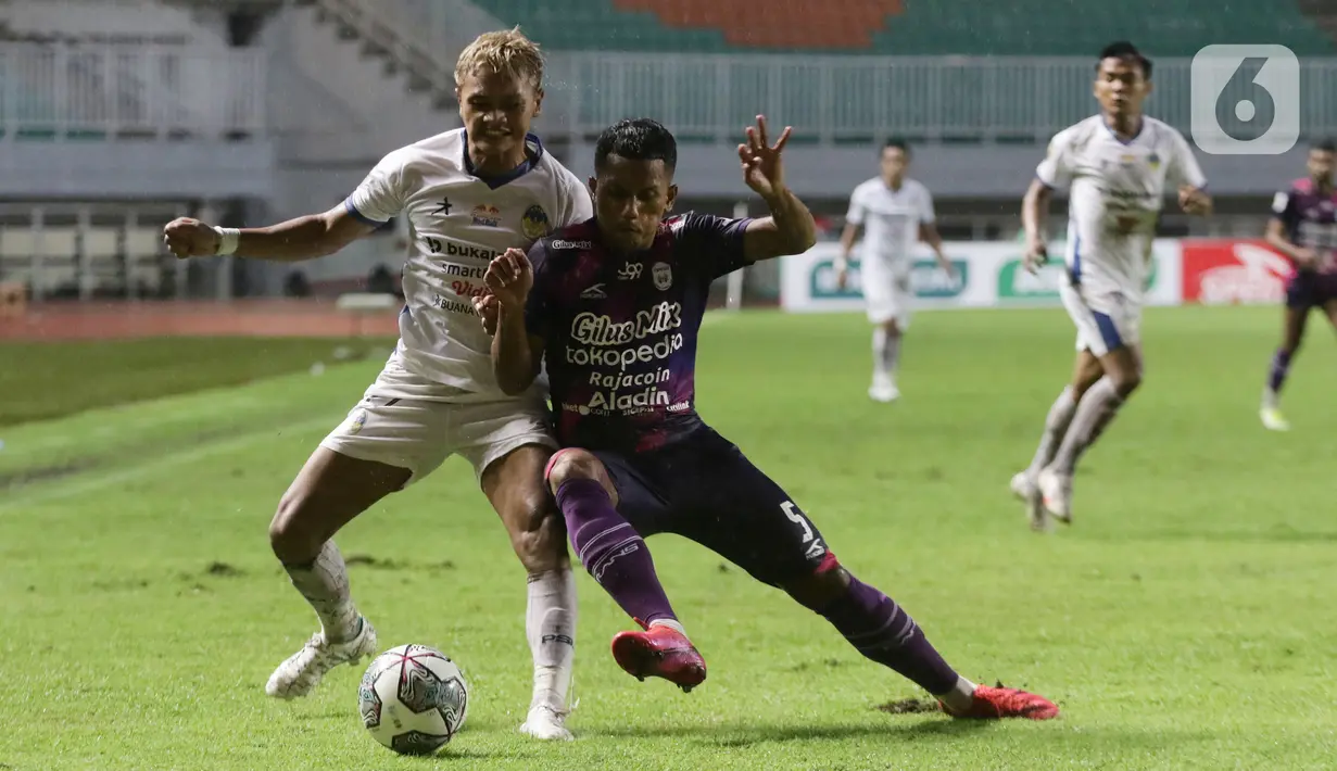 Pemain RANS Cilegon FC, Saddam Hi Tenang berebut bola dengan pemain PSIM Yogyakarta pada laga semifinal Liga 2 Indonesia 2021 di Stadion Pakansari, Kab Bogor, Senin (27/12/2021). RANS Cilegon unggul 3-0 serta memastikan satu tempat promosi ke Liga 1. (Liputan6.com/Helmi Fithriansyah)