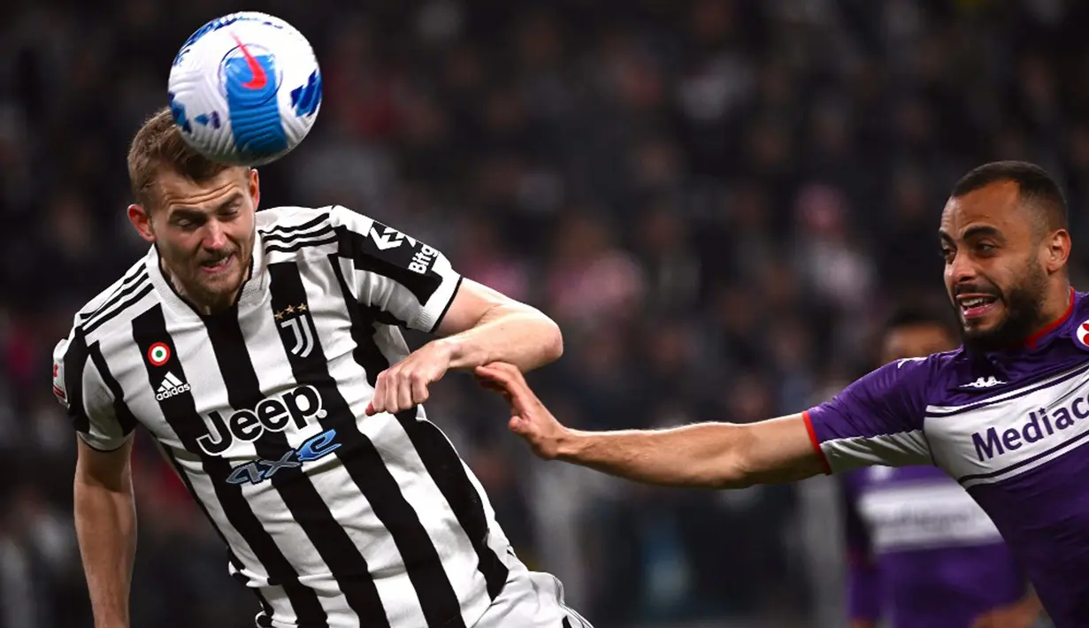 Pemain Juventus Matthijs De Ligt (kiri) menyundul bola di sebelah pemain Fiorentina Arthur Cabral pada pertandingan leg kedua semifinal Coppa Italia di Stadion Juventus, Turin, Italia, 20 April 2022. Juventus menang 2-0. (Marco BERTORELLO/AFP)