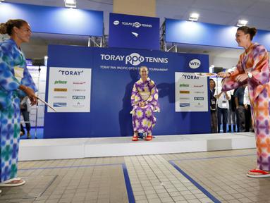 Petenis Monica Puig dan Agnieszka Radwanska bermain permainan tradisional Jepang yang disebut 'hagoita' disela turnamen tenis Pan Pacific Terbuka di Ariake Coliseum, Tokyo, Jepang, (20/9). (REUTERS/Issei Kato)