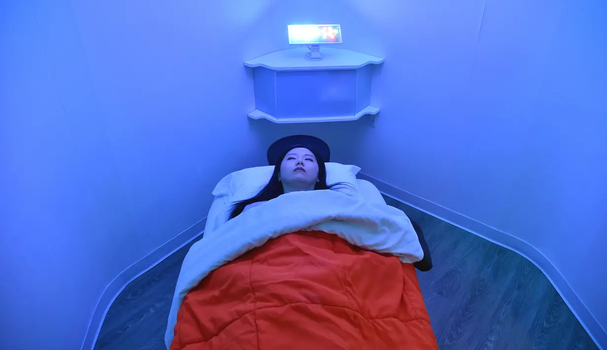 Laura Li tidur siang di YeloSpa, di New York, (1/5). Di New York, para pekerja dapat membayar kabin untuk tidur siang, dan mengisi ulang energi tubuh mereka tanpa harus kembali ke rumah. (AFP Photo/Hector Retamal)