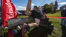Sebuah tim berjalan melewati rintangan saat mereka berlari selama North American Wife Carrying Championship di Sunday River Resort di Newry, Maine, pada 8 Oktober 2022. Lintasan juga harus memiliki tiga rintangan, yakni dua rintangan kering dan satu rintangan basah berupa kolam lumpur dengan dalam satu meter. (Joseph Prezioso / AFP)