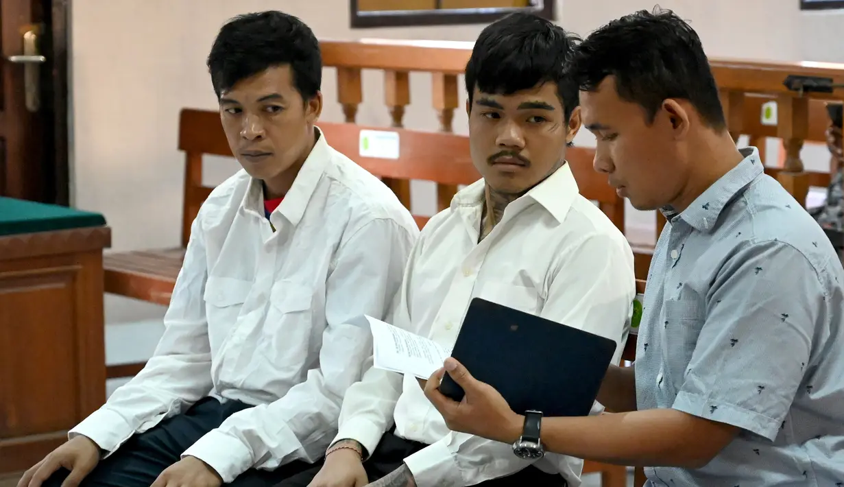 Warga negara Thailand, Prakob Seetasang (kiri) dan Adison Phonlamat (tengah) saat menjalani persidangan kasus penyelundupan narkoba di pengadilan Denpasar, Bali (23/9/2019). 2 warga Thailand tersebut menyelundupkan narkoba dengan menelan paket plastik. (AFP Photo/Sonny Tumbelaka)