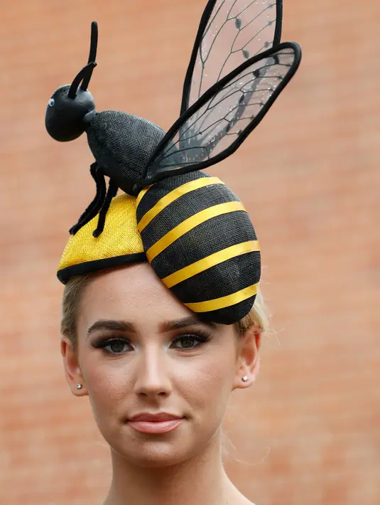Ella Reese berpose dengan topi atau fascinator unik bermotif lebah saat menghadiri ajang pacuan kuda Royal Ascot di Ascot, Inggris, Selasa (18/6/2019). Royal Ascot menjadi ajang bagi wanita Inggris untuk tampil dengan fascinator unik. (AP Photo/Alastair Grant)
