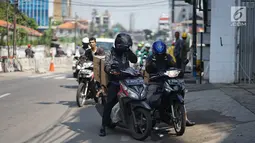 Pengendara motor berhenti saat melintas di Jalan KS Tubun, Petamburan, Jakarta Barat, Kamis (23/5/2019). Sisa gas air mata untuk membubarkan massa dalam kericuhan aksi 22 Mei masih terasa dan mengganggu aktvitas pengguna jalan, khususnya pengendara sepeda motor. (Liputan6.com/Immanuel Antonius)